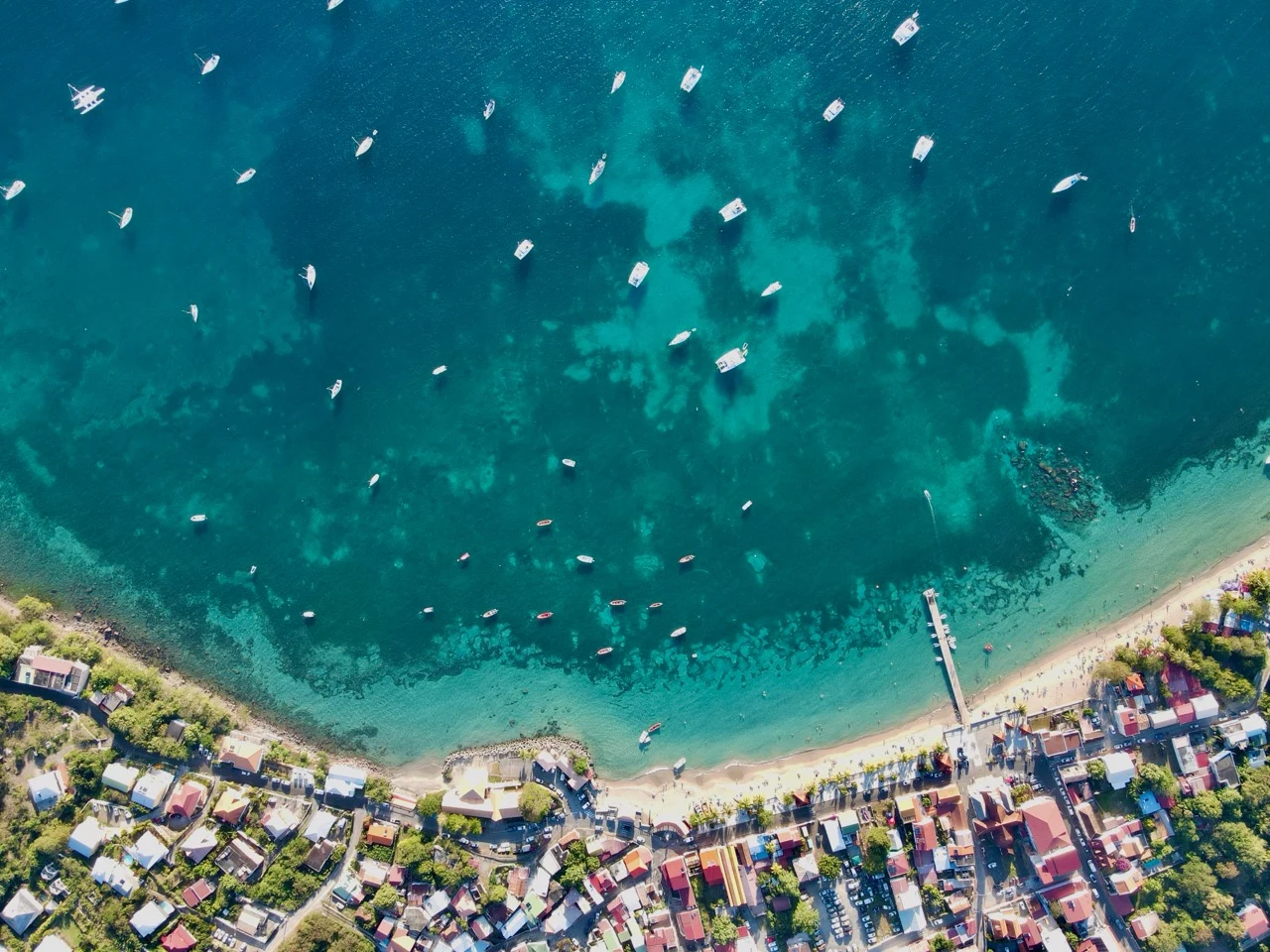 Vue aérienne d’une baie tropicale, de son bourg et de ses mouillages