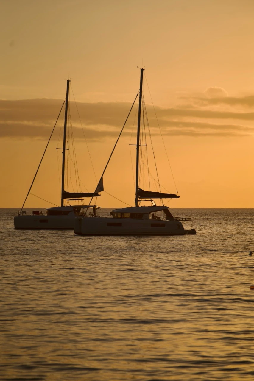 Deux catamarans au mouillage dans la lumière dorée du soir