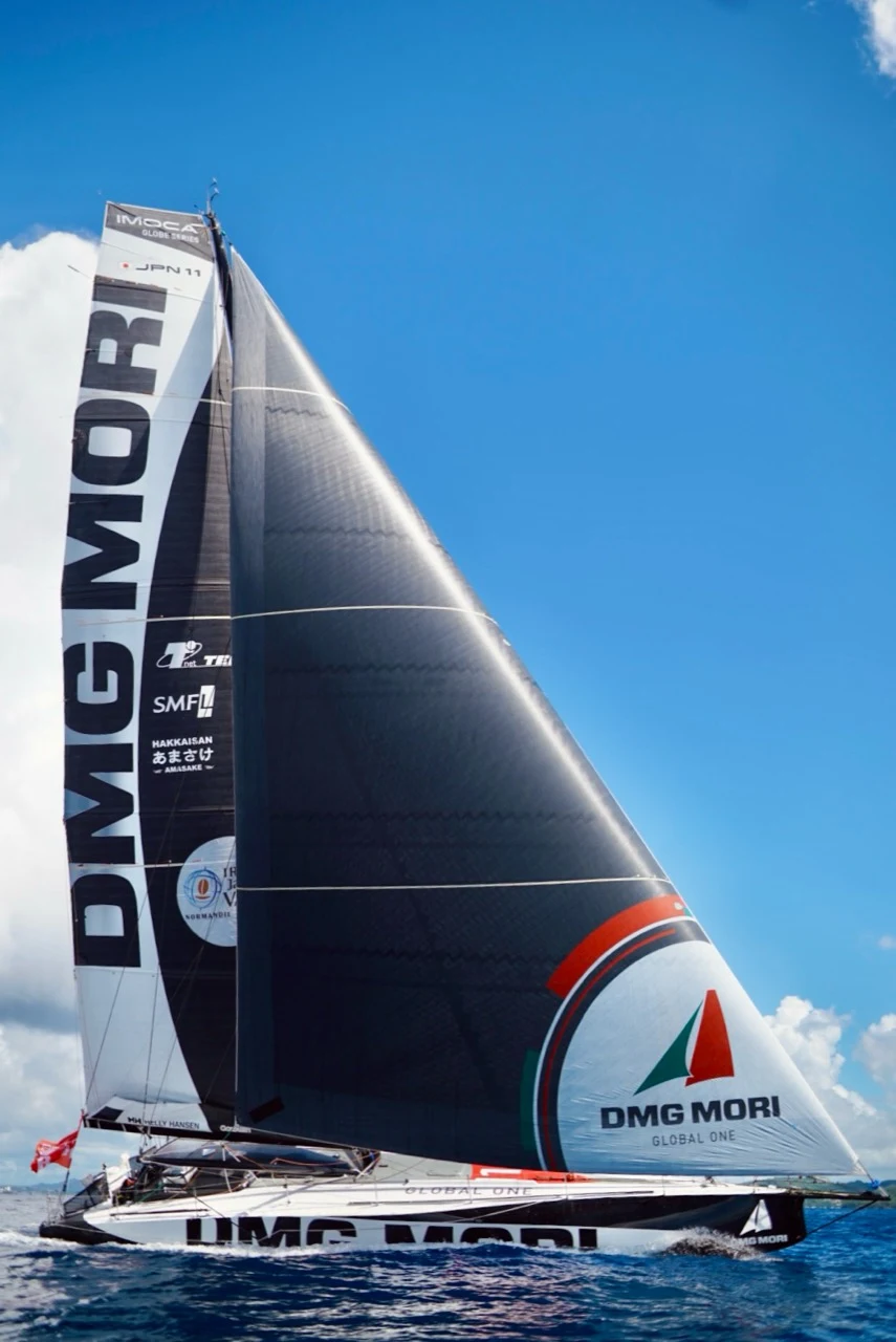 Voilier de course IMOCA sous sa grande voile noire
