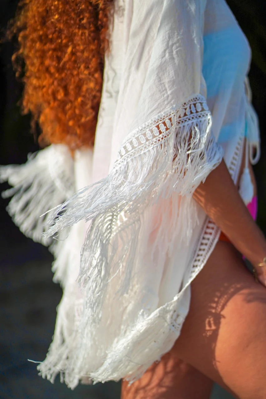 Détail en mouvement d’un kimono blanc à franges