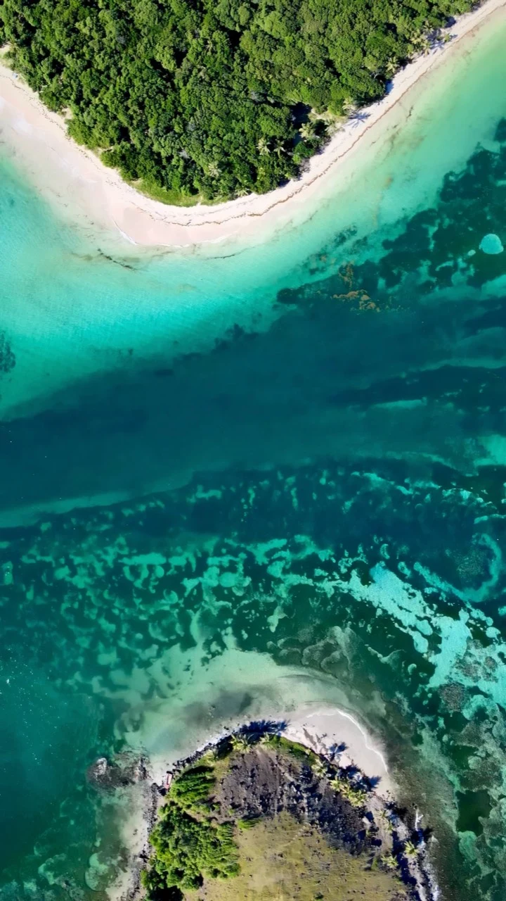 Vue aérienne de deux îlots tropicaux séparés par un récif turquoise