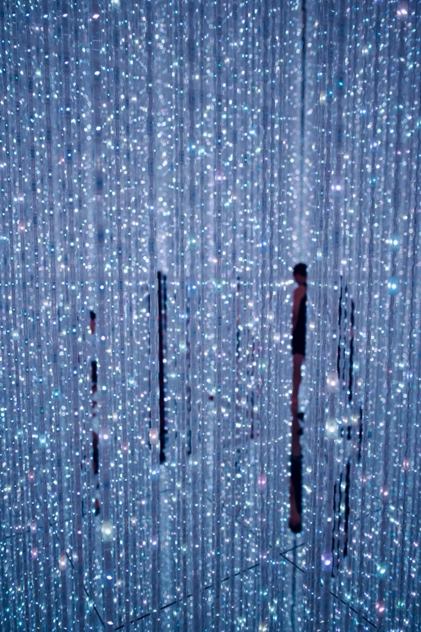 Silhouettes au milieu d’une installation lumineuse bleue